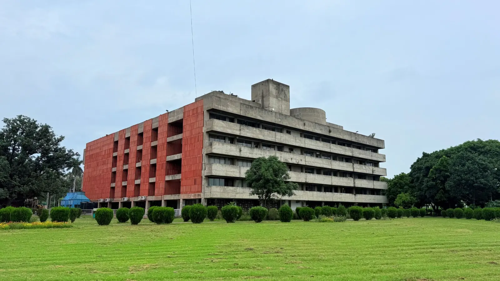 Edificio administrativo público detrás de un amplio césped, típico del mantenimiento de terrenos de agencias.