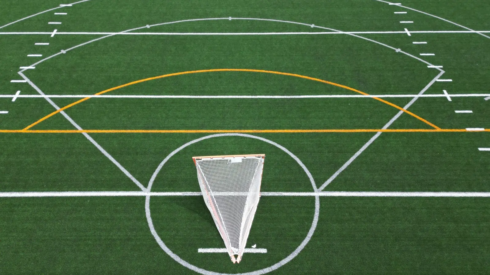 Aerial view of an empty public sports field with marked lines, representing organic grounds care services for public sites.